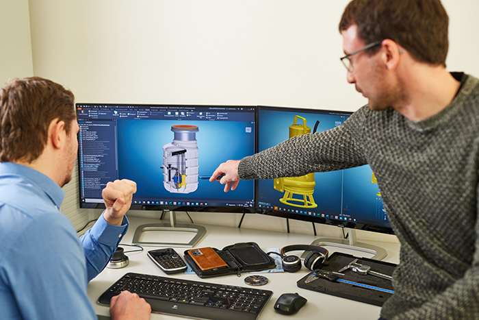 Mitarbeiter der Konstruktion bei der Besprechung anhand von CAD Daten